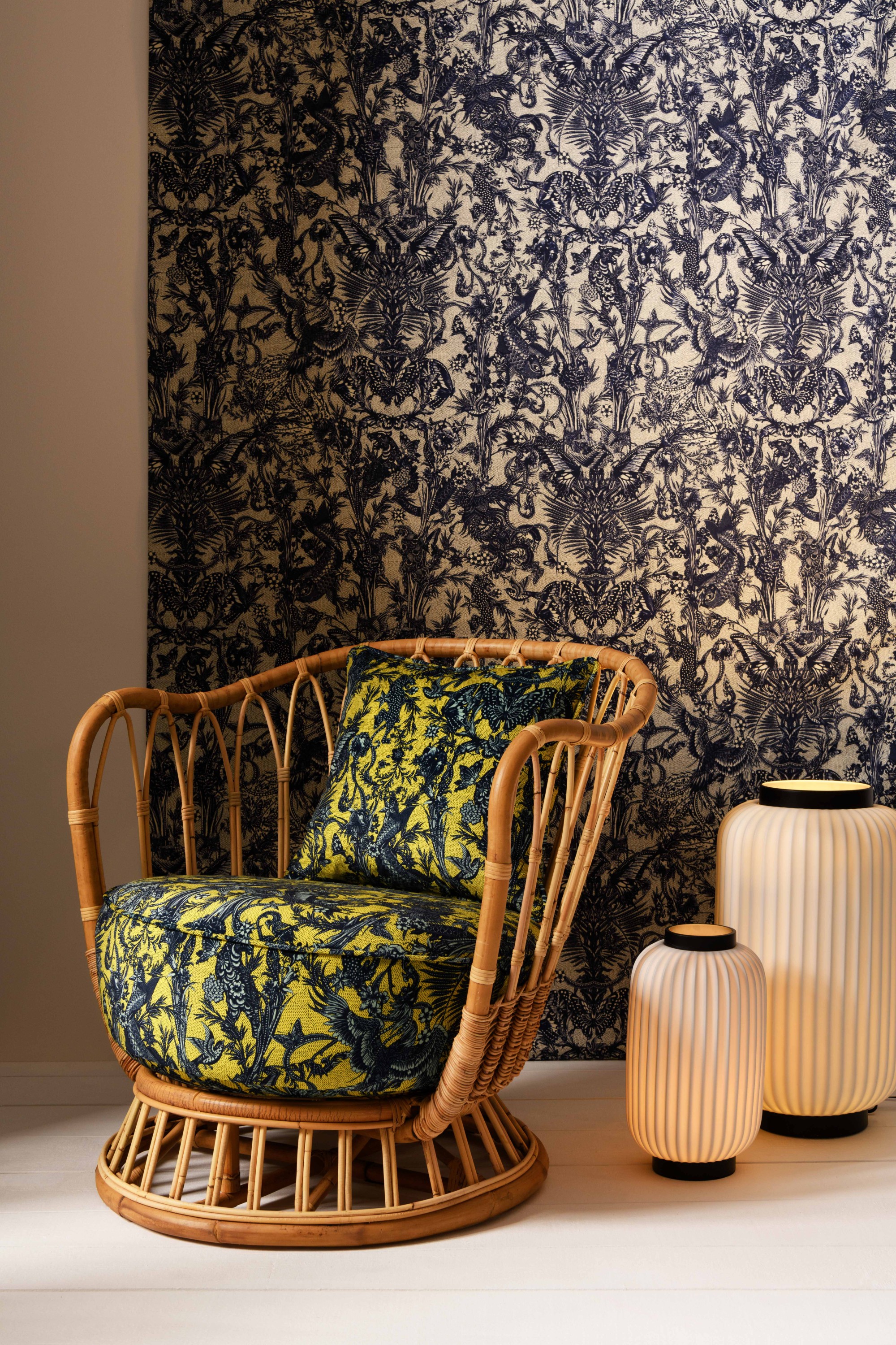 Panneau mural tissu JAVANAISE 3618, col. Indigo. Fauteuil "Grace" - Gubi, tissu JAVANAISE 3618, col. Limoncello. Lampes de sol "Lune" – CFOC.